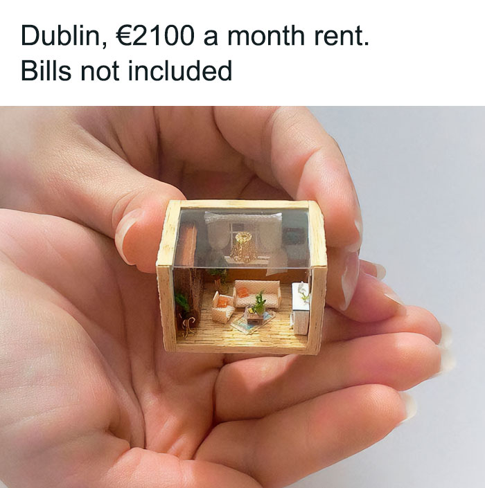 Hand holding a miniature model of a tiny living room, highlighting Ireland rent prices and housing challenges.