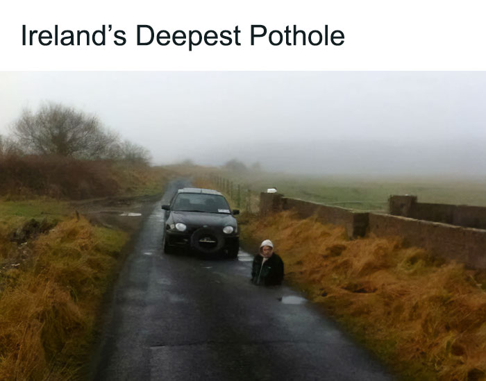 Man standing in Ireland’s deepest pothole on a misty rural road, illustrating unique Ireland country scenes.