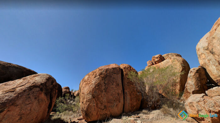 Large reddish boulders in a rocky desert landscape under clear blue sky, capturing amusing and ridiculous Google Maps moments.