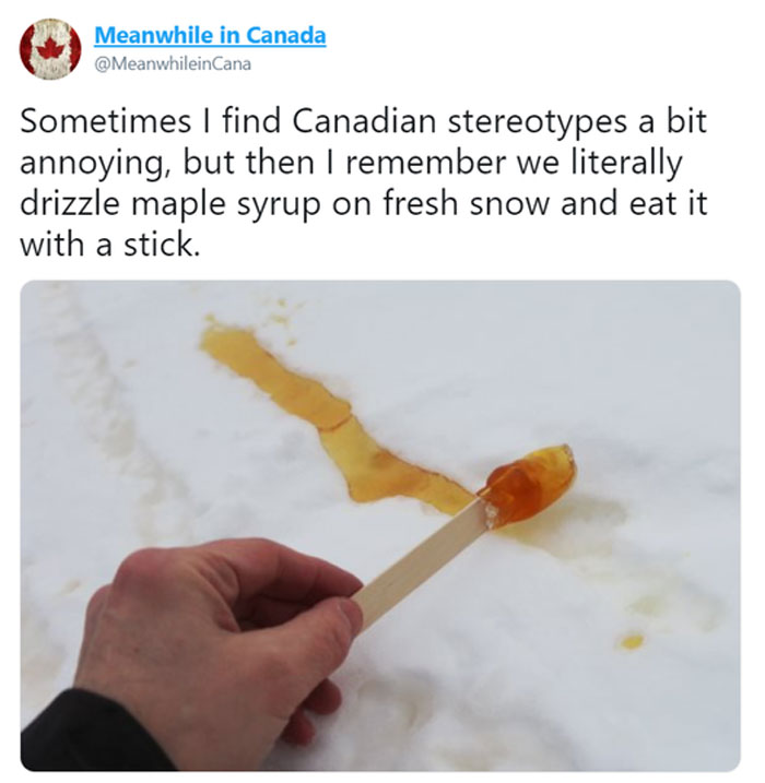 Hand holding a stick with maple syrup on snow, highlighting Canadian culture.