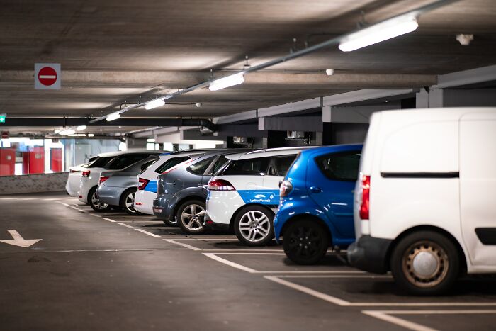 Cars parked in a dimly lit underground parking garage, illustrating fear of going downstairs after turning off the lights.