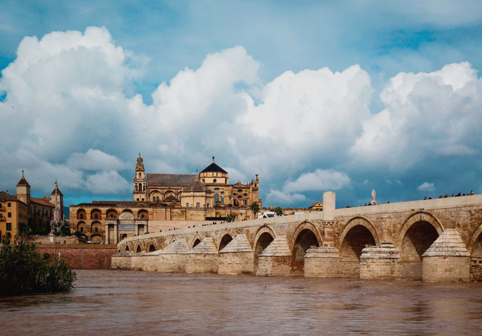 Roman bridge of Córdoba with river and buildings near