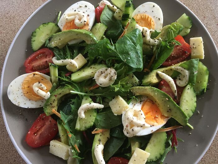 Salad with boiled eggs, avocado, cucumber, tomatoes, cheese, and mayonnaise, featured in a dish rating Facebook group.