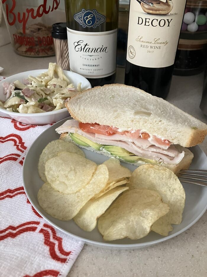 Sandwich with chips and pasta salad on a plate, showcasing dishes rated in a popular Facebook food group.