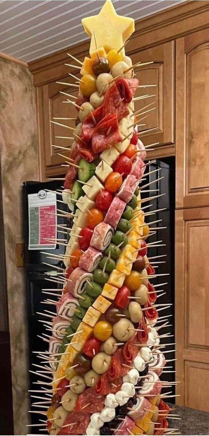 Tall charcuterie cone with meats, cheeses, olives, and veggies on toothpicks, a unique dish rated on Facebook groups.