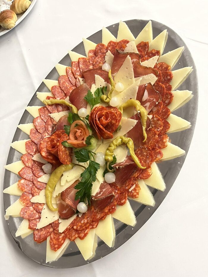 Charcuterie platter with assorted cured meats, cheese, peppers, and garnishes, featured in a dish rating Facebook group.