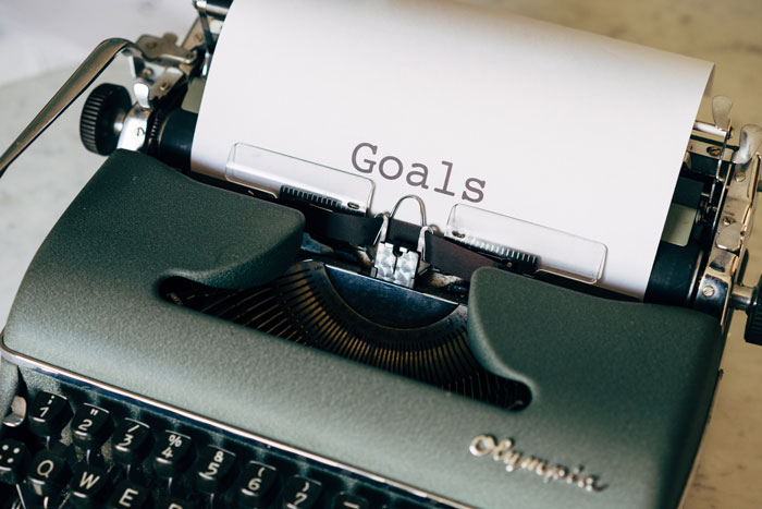 Typewriter with a paper titled "Goals," symbolizing cool New Year's eve resolutions and plans.