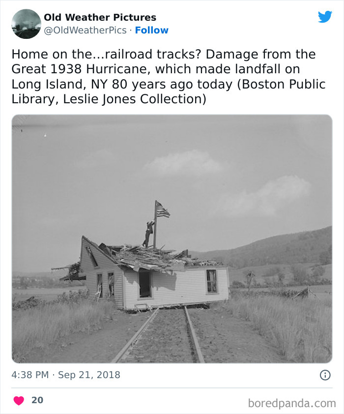 Black and white photo of extreme weather damage showing a house lifted onto railroad tracks after a historic hurricane.