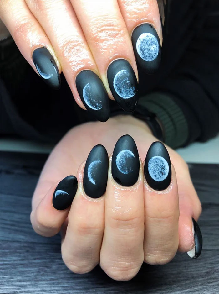 Matte black nails featuring detailed moon phase designs, showcasing creative nail art ideas for unique tiny artworks.
