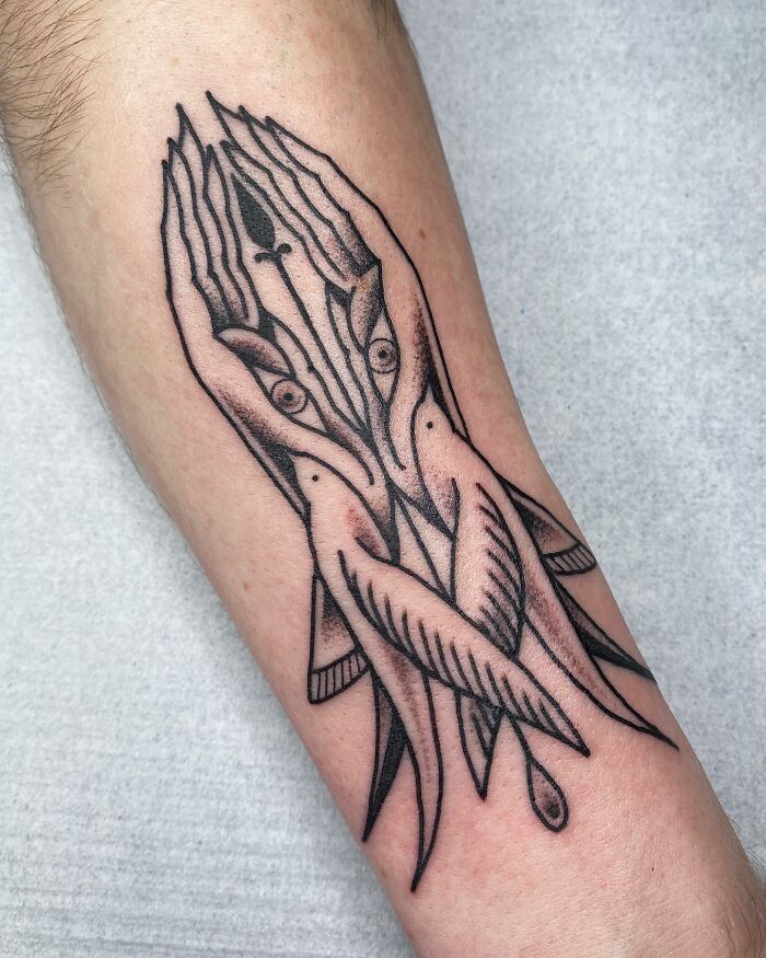 Optical illusion tattoo on arm featuring intertwined hands and fish, creating a mind-bending design.