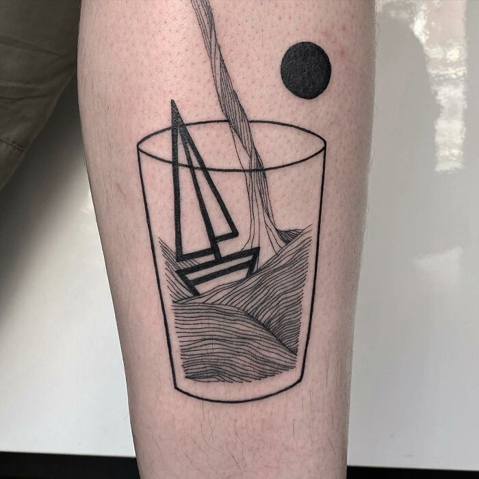 Geometric tattoo of a boat and water in a glass on skin.