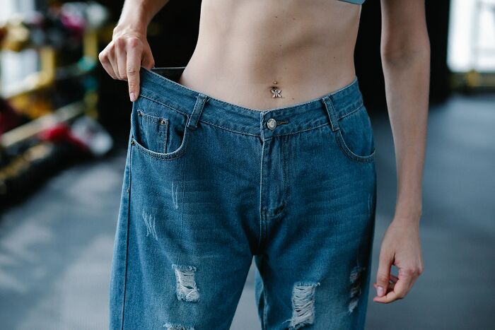 Person showing loose jeans to highlight alarming number of individuals not knowing basic facts about weight loss.
