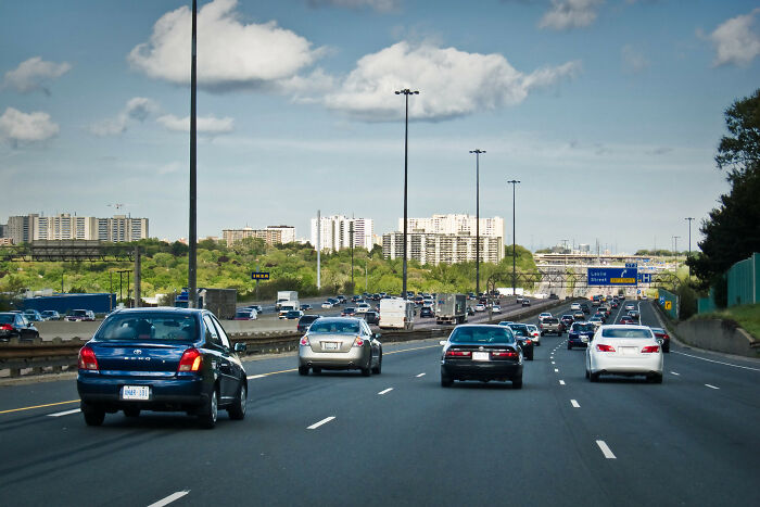 Busy highway with multiple cars driving toward city buildings, illustrating people noticing alarming lack of basic facts knowledge.