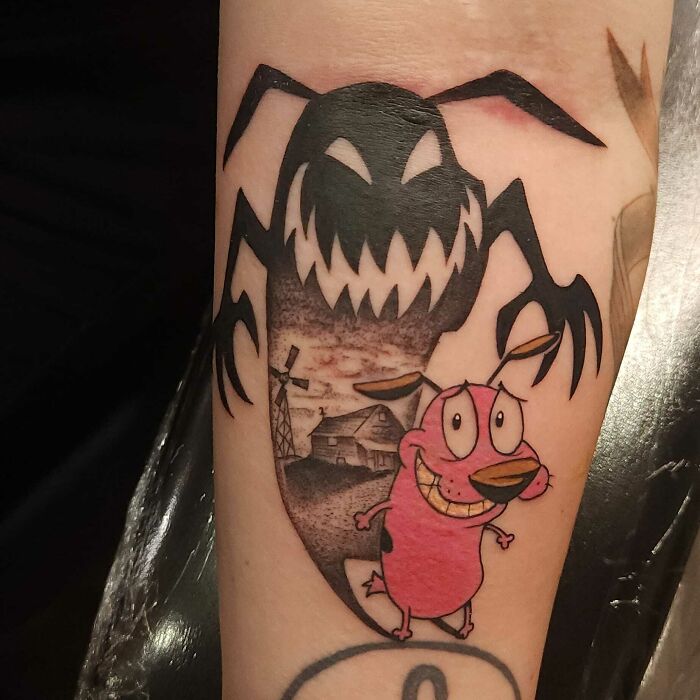 Beautifully executed tattoo of Courage the Cowardly Dog with a shadowy figure background scene.