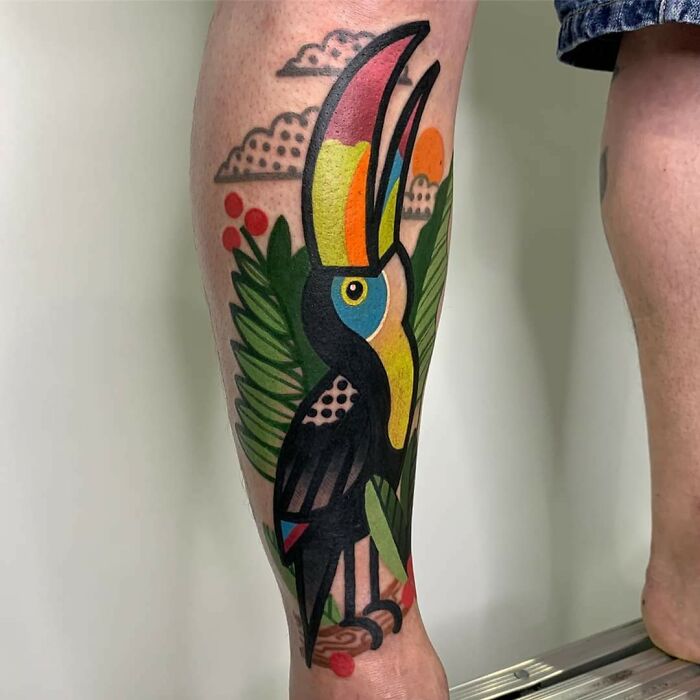 Colorful toucan tattoo expertly executed on a person's leg.