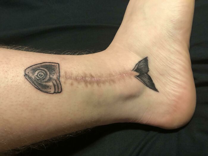 Unique fish tattoo creatively aligned with a scar, showcasing a beautiful tattoo idea executed perfectly.