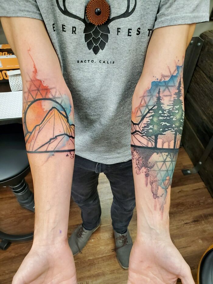 Beautiful forearm tattoos featuring a mountain and forest landscape executed perfectly.