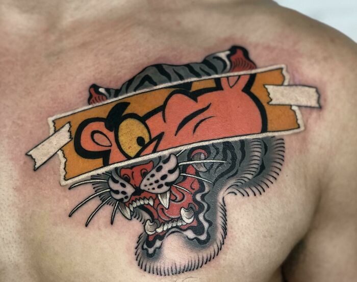 Beautiful tattoo idea of layered tiger and cartoon designs on a person's chest.