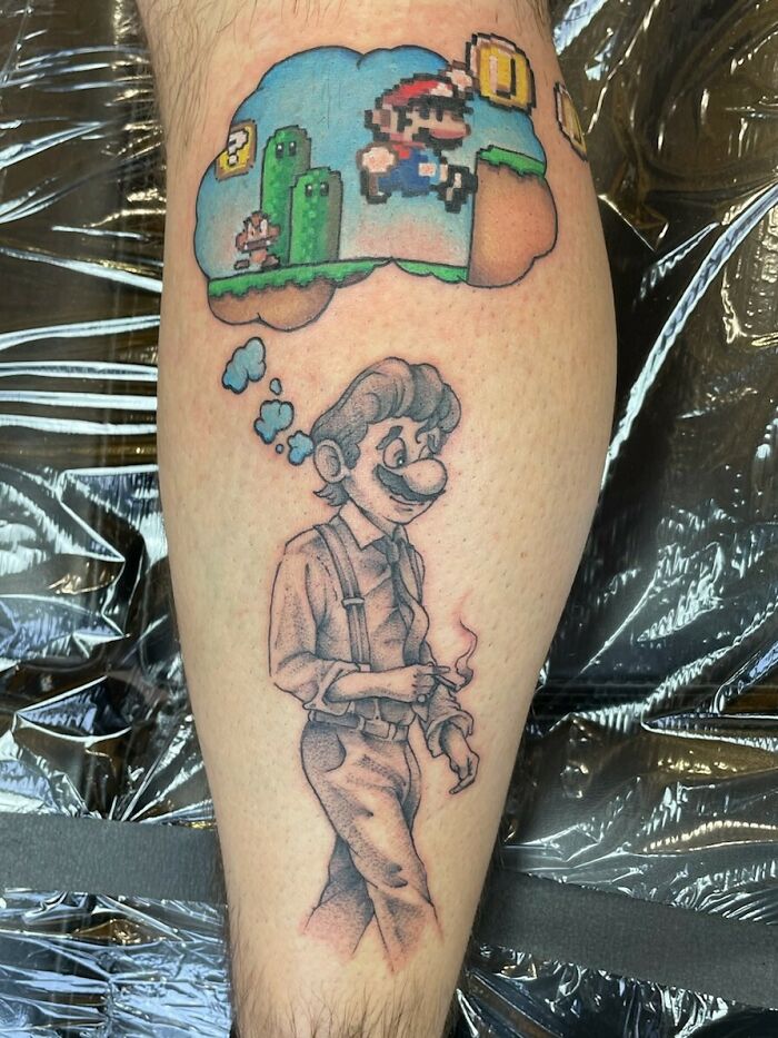Beautiful tattoo idea combining colorful pixel art and grayscale sketch of a character on a person's calf.