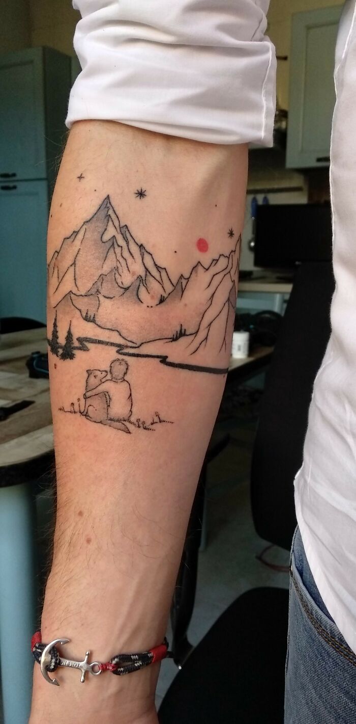 Beautiful tattoo of mountains and stars on an arm, featuring a person with a bear, done perfectly.