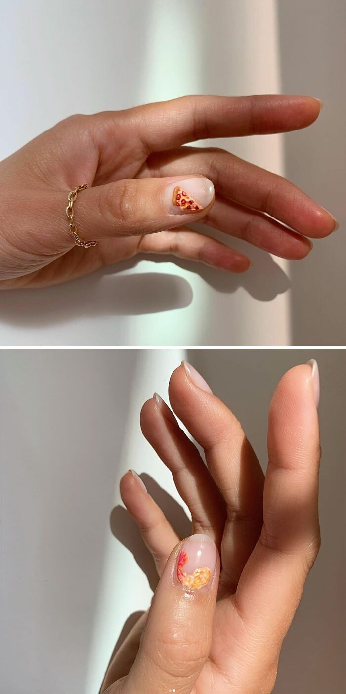 Hand with creative nail art design featuring tiny pizza and abstract shapes.
