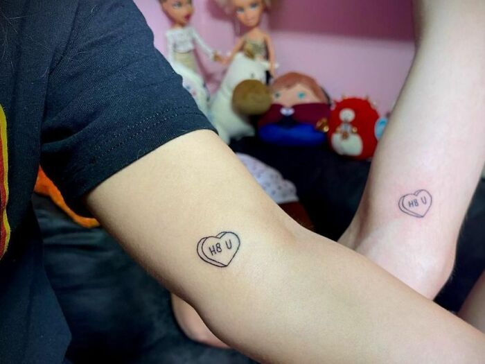 Brother and sister tattoos on arms, featuring matching heart designs with "H8 U" text.