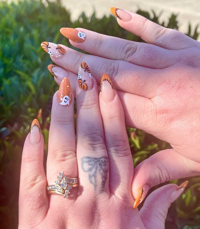Halloween-themed nail art design featuring pumpkins and ghosts with orange tips, showcasing creative nail art ideas.