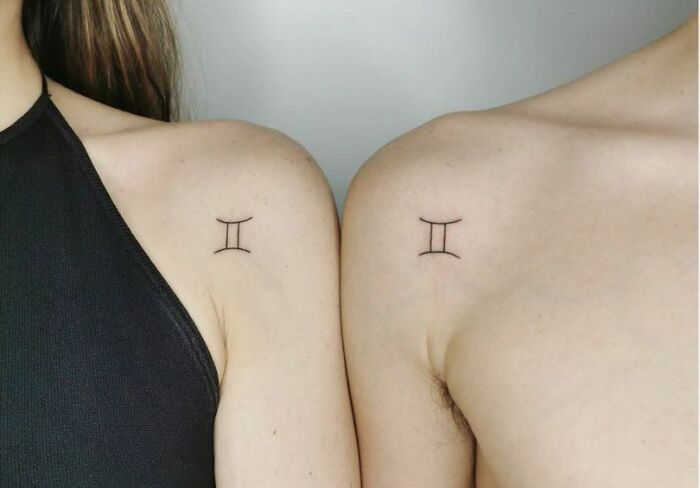 Minimalist brother and sister tattoos on shoulders featuring Gemini astrological symbols.