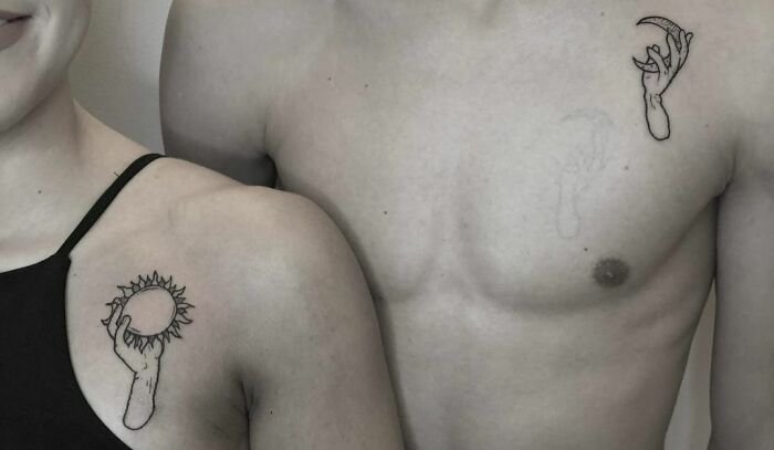 Brother and sister tattoos featuring hands holding the sun and moon on their shoulders.