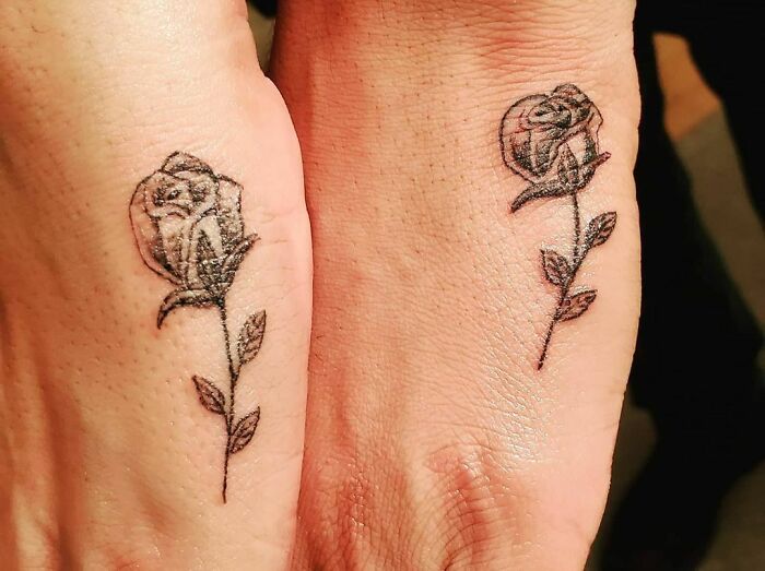 Two matching simple brother and sister rose tattoos on wrists.