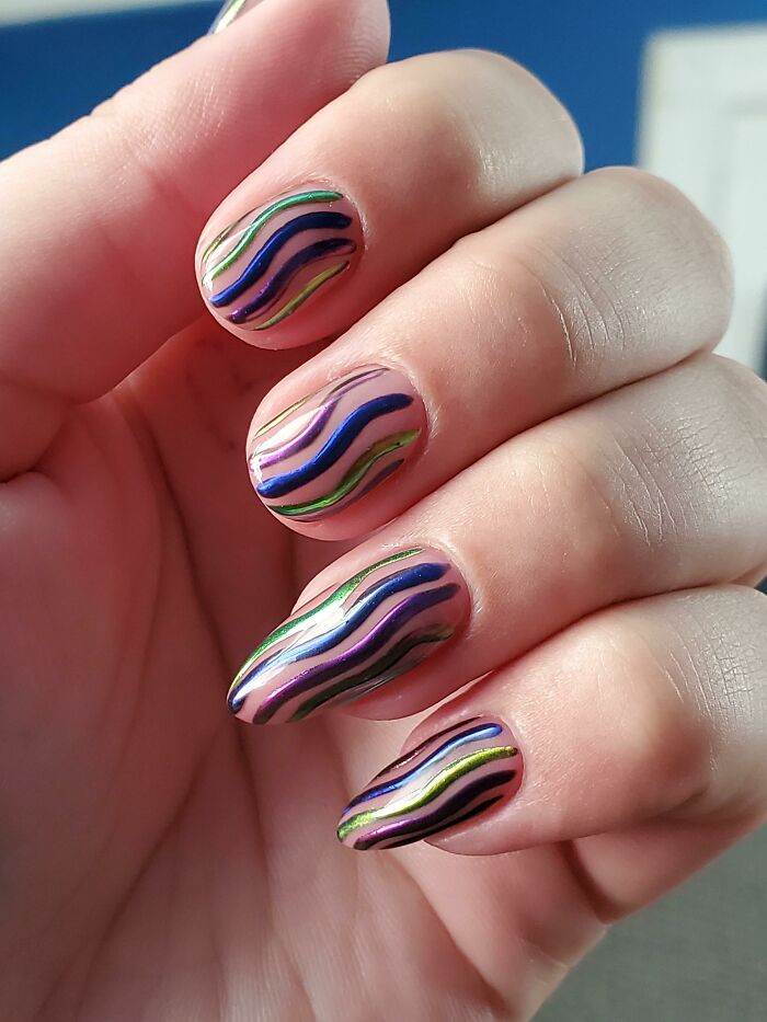 Colorful wavy nail art design on manicured nails, showcasing trendy nail art ideas.
