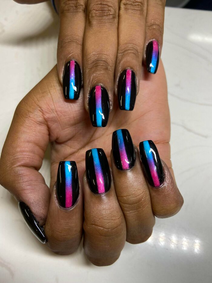 Glossy black nails with vertical pink and blue gradient stripes on medium-length square nails, showcasing creative nail art ideas.