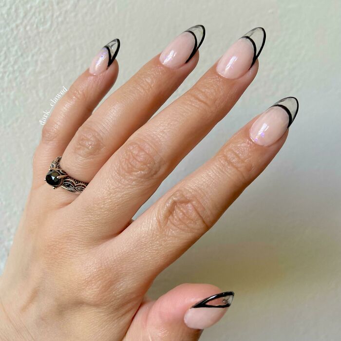 Hand with black and clear abstract nail art design, showcasing elegant nail art ideas for delicate tiny artworks.
