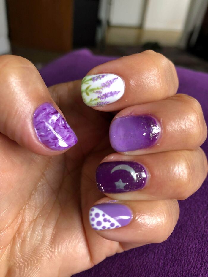 Nails featuring purple floral, gradient, moon and star, and polka dot designs as creative nail art ideas.