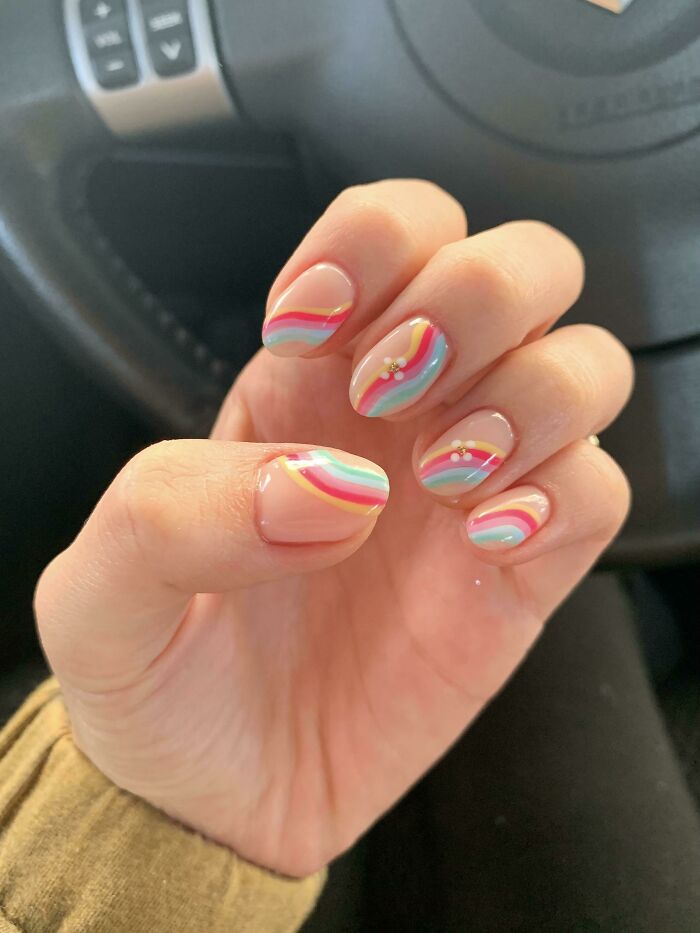 Colorful nail art with wavy pastel designs on a hand, showcasing a creative nail art idea.