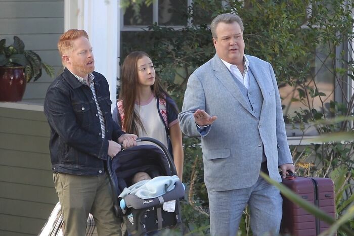 Mitch carrying baby, Cam carrying a suitcase 