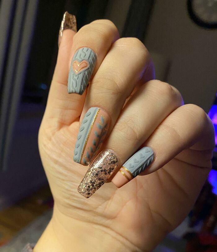Stylish nail art with gray cable knit pattern and glitter accents.