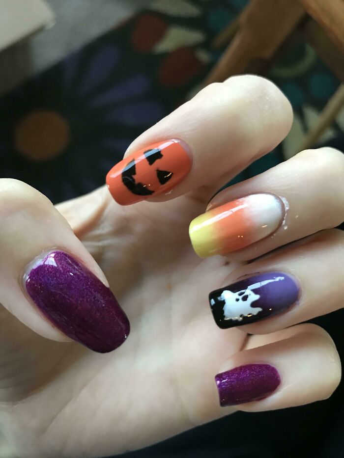 Halloween-themed nail art featuring a jack-o'-lantern, ghost, and ombre designs on manicured nails. Perfect nail art ideas.