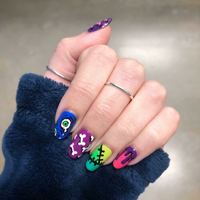 Colorful nail art with unique designs featuring bones, eyes, and stitches, perfect for your next appointment.