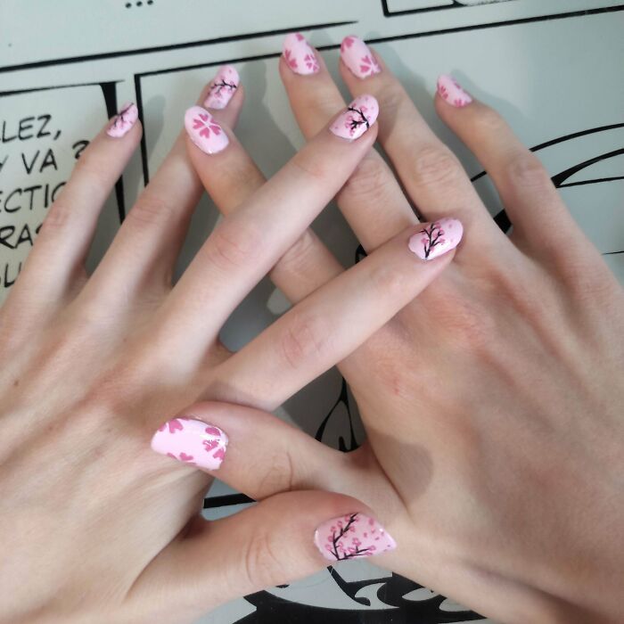 Pink floral nail art designs on hands, showcasing creative nail art ideas.