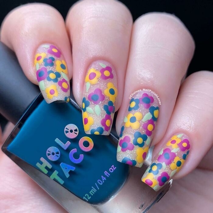 Colorful floral nail art design with Holo Taco polish bottle, showcasing trendy nail art ideas.