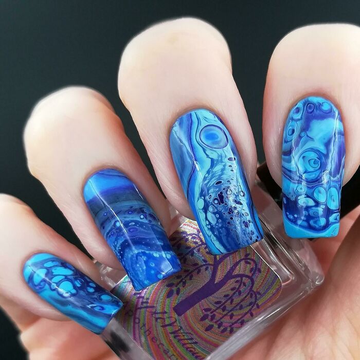 Blue marbled nails with intricate details showcasing creative nail art ideas on long squared nails.