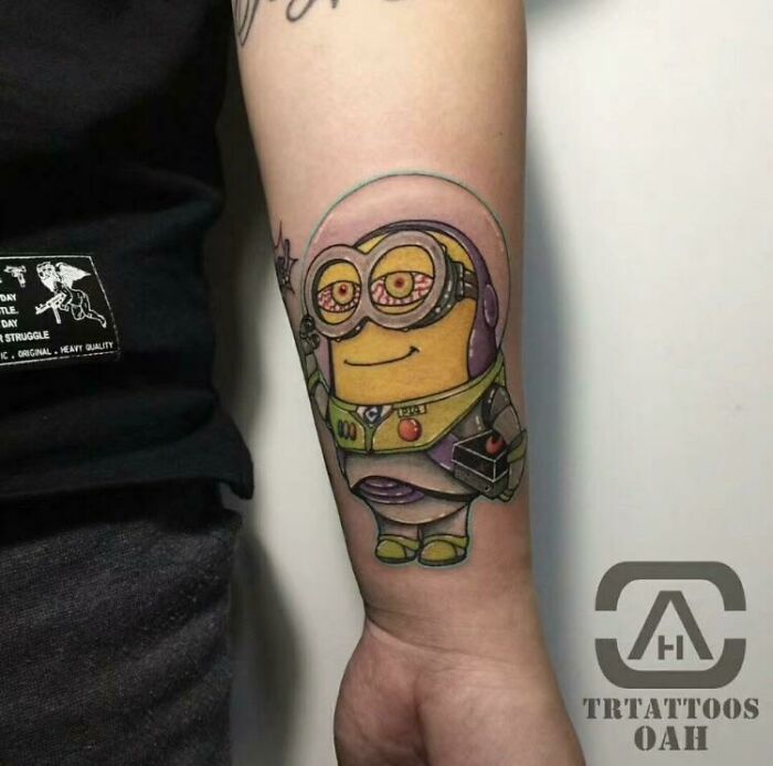 Quality tattoo of a character in a space suit on a forearm, showcasing detailed yet unusual design choices.