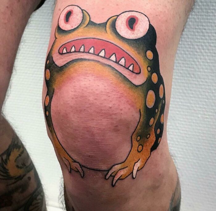 Frog tattoo design on a knee with vibrant colors, showcasing a peculiar and humorous appearance.