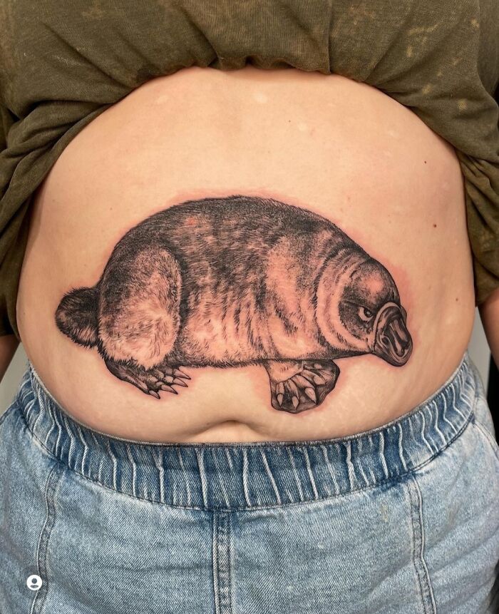 A tattoo of a mole on the stomach, showcasing poor design quality.