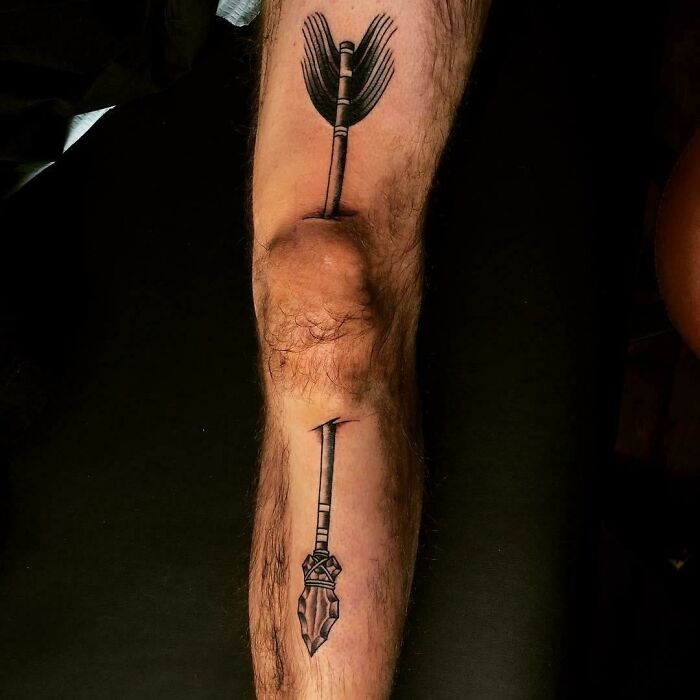 Arrow tattoo on a leg with knee cleverly incorporated into the design, illustrating a creative but poorly executed tattoo.