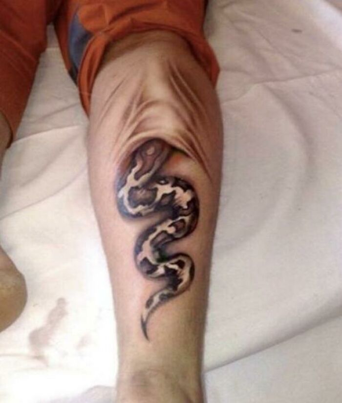 Quality tattoo of a snake wrapped around a knee, with skin detail adding a surreal effect.