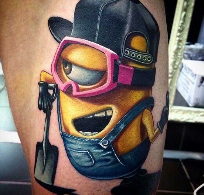 Quality tattoo depicting a recognizable cartoon character in overalls, pink goggles, and a cap, holding a small shovel.