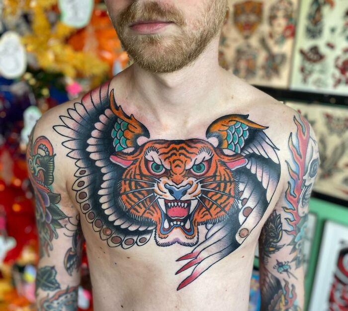 Flying tiger with wings tattoo on chest, showcasing trippy tattoo art in vibrant colors.