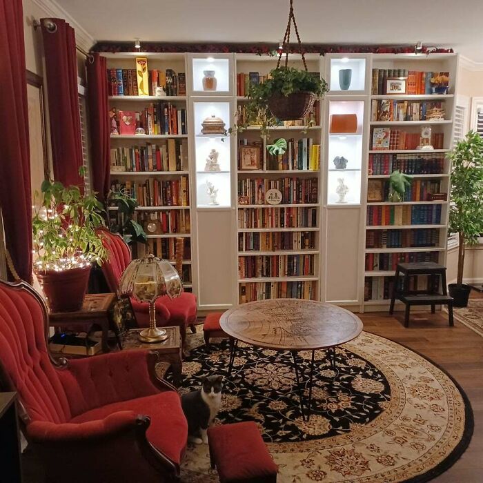 Two red chairs next to a round coffee table 